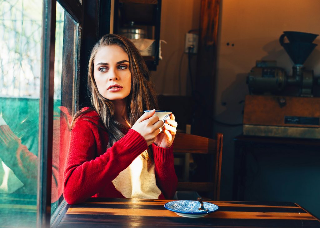 Женщина пьёт чай на террасе летнего кафе в одиночестве — микровосстановление при эмоциональном выгорании